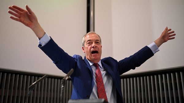 Nigel Farage gestures to the crowd during a speech in London in which he was interrupted by protesters this afternoon