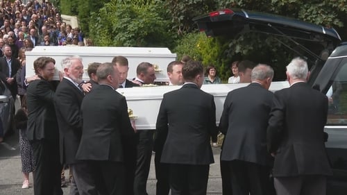 Two white coffins were carried together in one hearse