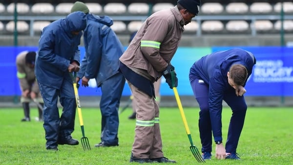 Groundspeople attempt to prepare the field at the Athlone Stadium before it was deemed unplayable