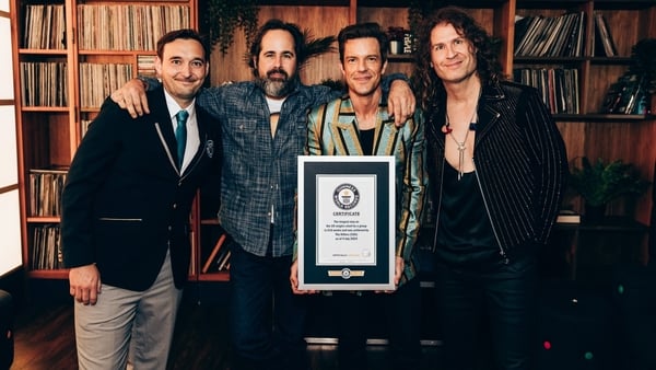 Guinness World Records Adjudicator Will Munford (left) presenting The Killers with their certificate after their song, Mr Brightside, broke the record for the longest stay on UK singles chart by a group, with 416 weeks