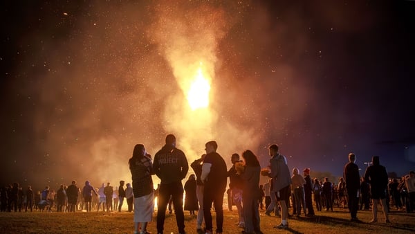 Members of the public watch the burning of the Craigyhill bonfire in Larne