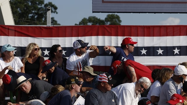 Freagraíonn daoine ag an rally nuair a chualathas fuaim na ngunnaí agus an tUasal Trump ag labhairt leis an slua