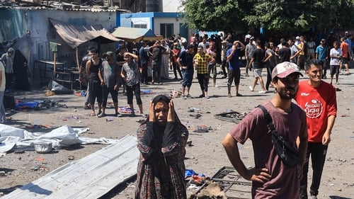 Palestinians check the destruction at the UN-run Al-Razi School in the Nuseirat refugee camp after an Israeli strike