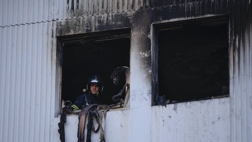 A French Firefighter looks out of a window after extinguishing a fire that broke out overnight at a residential building in Nice