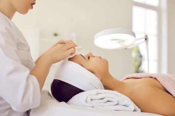 Woman lies in salon getting injectables into her face