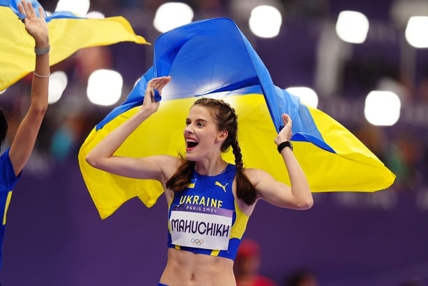 Yaroslava Mahuchikh wore blue and yellow eye-liner and a berry lipstick whilst cheering at the Olympics with a Ukrainian flag