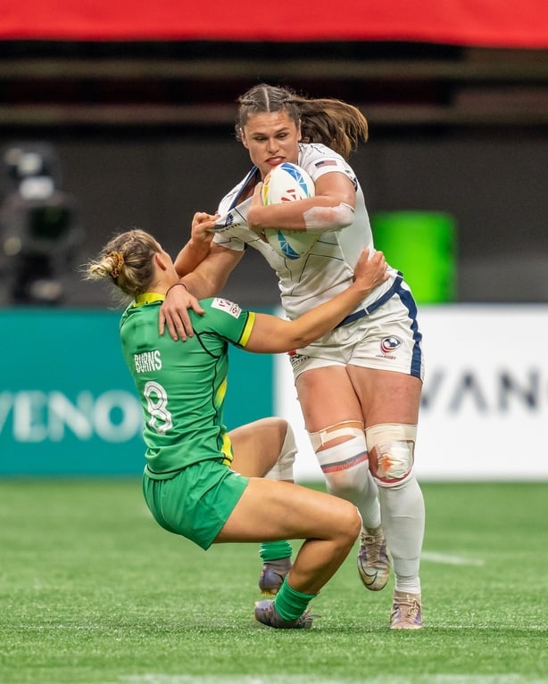 Ilona Maher executes a tackle on the rugby pitch in red lipstick