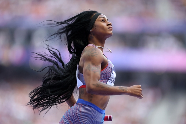 Sha'Carri Richardson crosses the finish line of a race with long blond hair