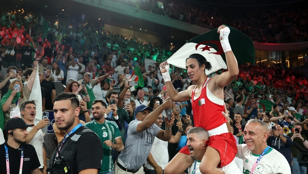 Imane Khelif celebrates winning the gold medal with her coaches Mohamed Chaoua and Mohamed Al-Shawa