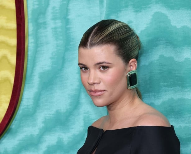 Sofia Richie Grainge wears a slicked back middle-part bun with large statement earrings on red carpet