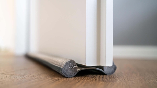 Draught excluder stopping air from escaping under the door