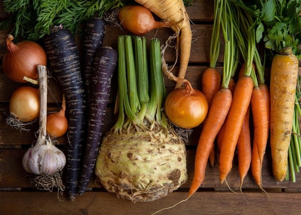 Assortment of colourful root vegetables fresh from the farmer's market including onions, garlic and carrots