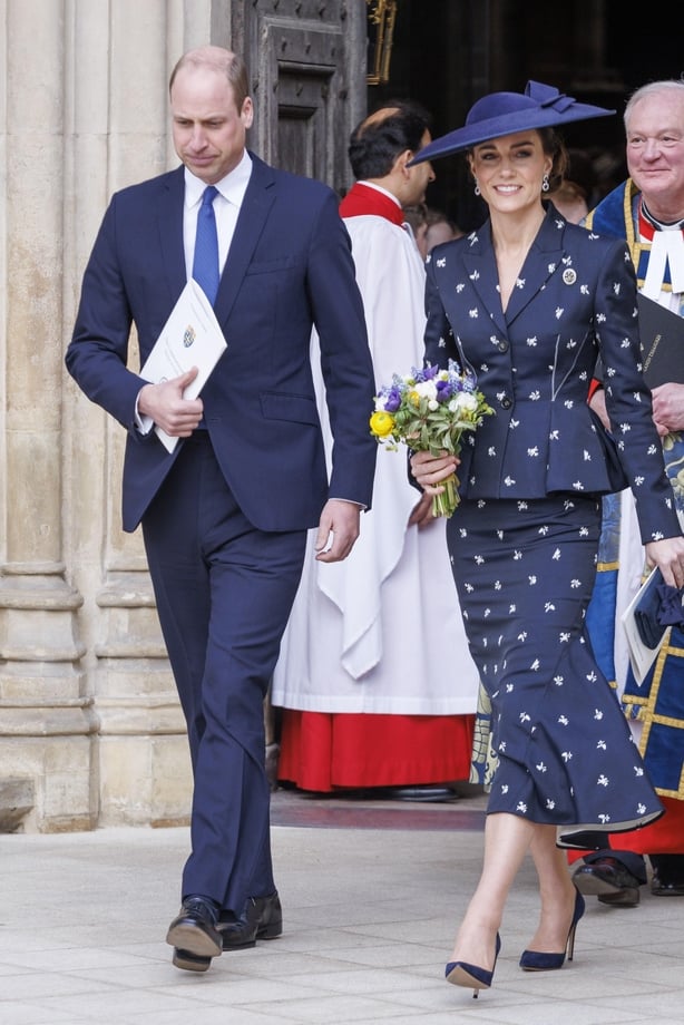 The Prince and Princess of Wales walk out of the commonwealth day service in matching navy suit ensembles