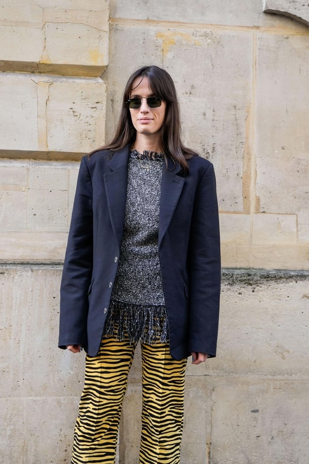 Woman poses in navy oversized blazer, grey wool jumper and tiger print trousers