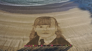 New York firefighters form guard of honour at sand art portrait in Waterford
