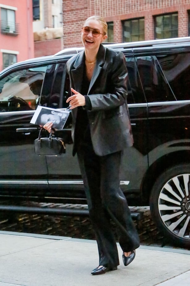 Gig Hadid gets out of taxi in black trousers, black leather pumps and a black leather blazer