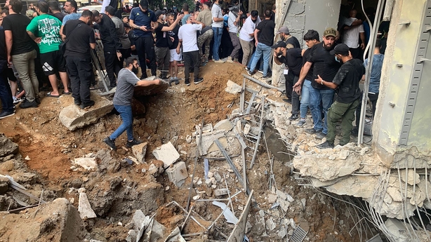 People inspect the damge from the blast in Beirut's southern suburbs today