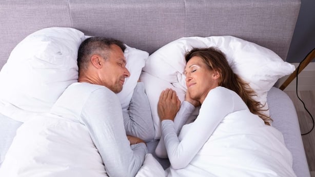 High angle view of middle age couple sleeping in bed