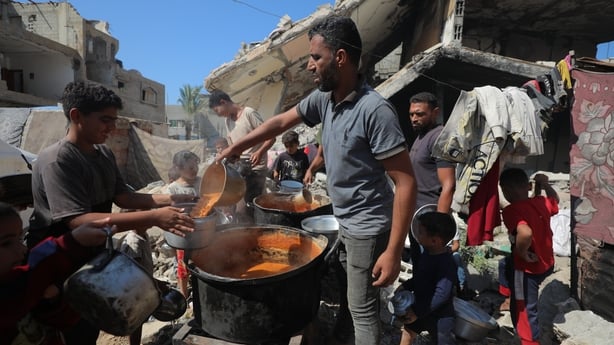 People living in the Ez-Zawayide area of Gaza city, queue for food today
