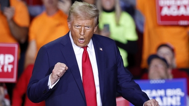Trump dances as he walks on stage during campaign rally in Michigan