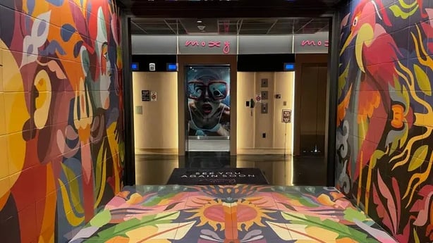 The colourful lobby of the Moxy Miami Wynwood which includes a picture in the lift of the same woman featured on a giant mural on the side of the building (Ben Mitchell/PA)