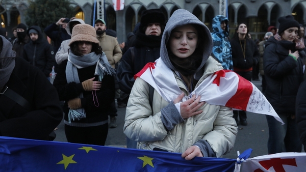 People, carrying EU and Georgian flag, protest in front of the parliament building in Tiblisi