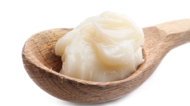 Spoon with lard on white background