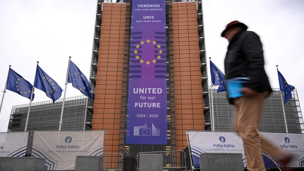 People walk past the European Commission headquarters building in Brussels, Belgium
