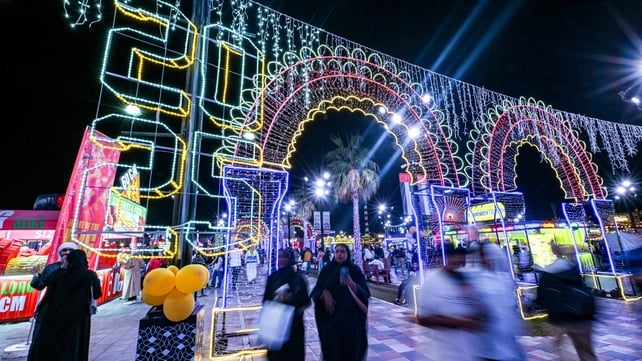 People walk at the Sheikh Zayed Heritage Festival as they await the New Years Eve fireworks and drone show in Abu Dhabi