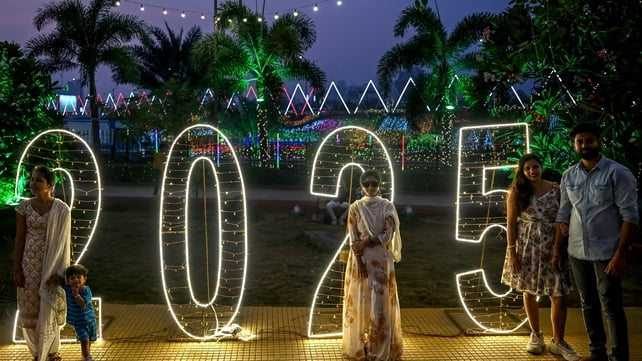 People pose for photos along the promenade in Mumbai, India