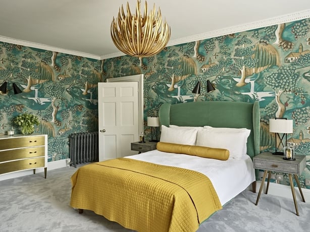 Bold, richly detailed wall pattern pairs beautifully with an ornate overhead light fixture