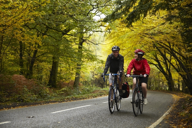 Man and woman couple road cycling on race bike outdoor in nature