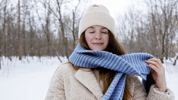 Woman holding cup of tea and enjoying snow