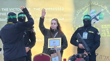 Released Israeli hostage waves from stage during release