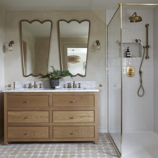 Statement mirrors paired with an oak vanity unit creates a striking focal point in this timeless en-suite bathroom by Souq.Studio (Souq.Studio/Anna Stathaki/PA)