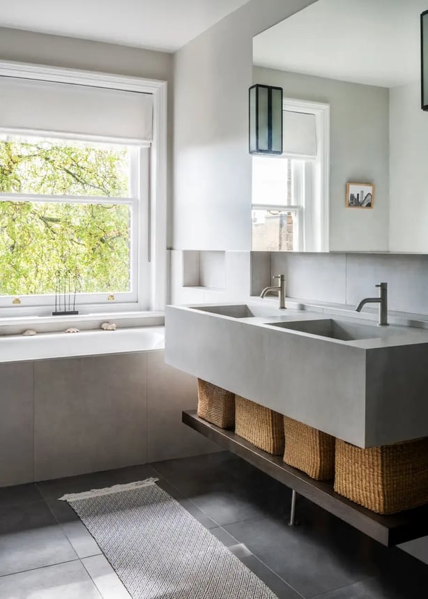 A bespoke vanity unit with spacious double sinks adds style and ample storage space with shelving for wicker baskets in this bathroom by Aflux Designs (Aflux Designs/Vigo Jansons/PA)