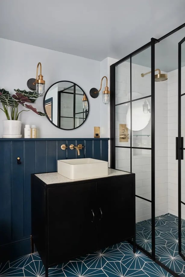 Stylish wall sconces add functional and ambient lighting to this transitional bathroom by Muchmore Design (Muchmore Design/Chris Snook/PA)
