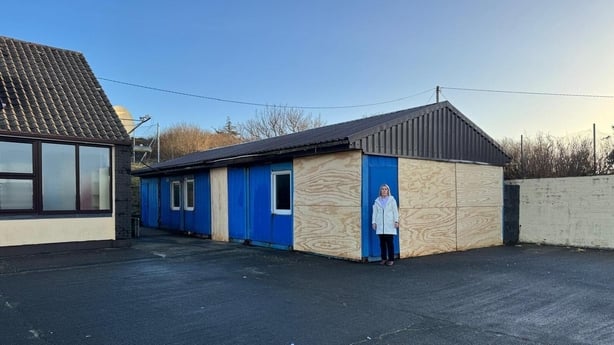 Principal standing in front of the school boarded up