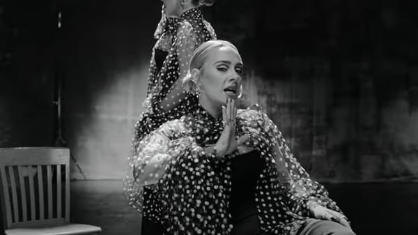 The four-minute promo sees the singer, 33, sitting in a sparsely decorated room surrounded by wooden chairs, with apples scattered across its concrete floor